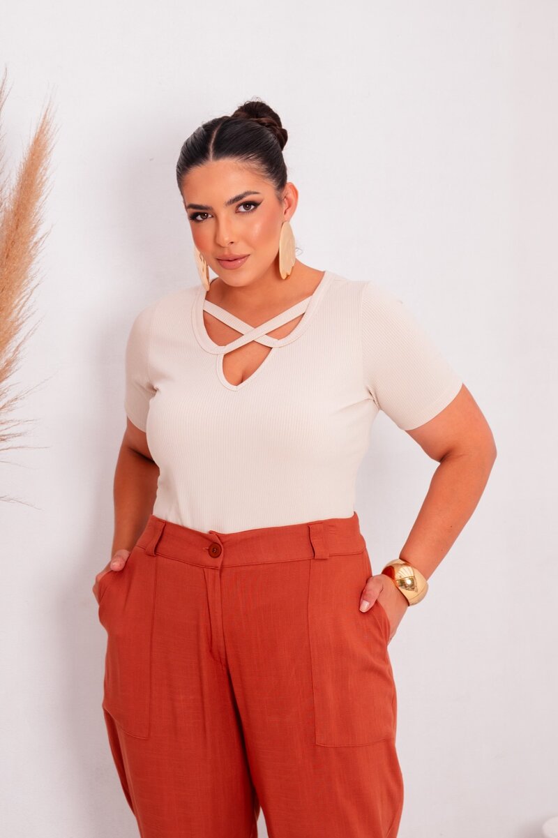 Blusa clara com detalhes em X e calça laranja
