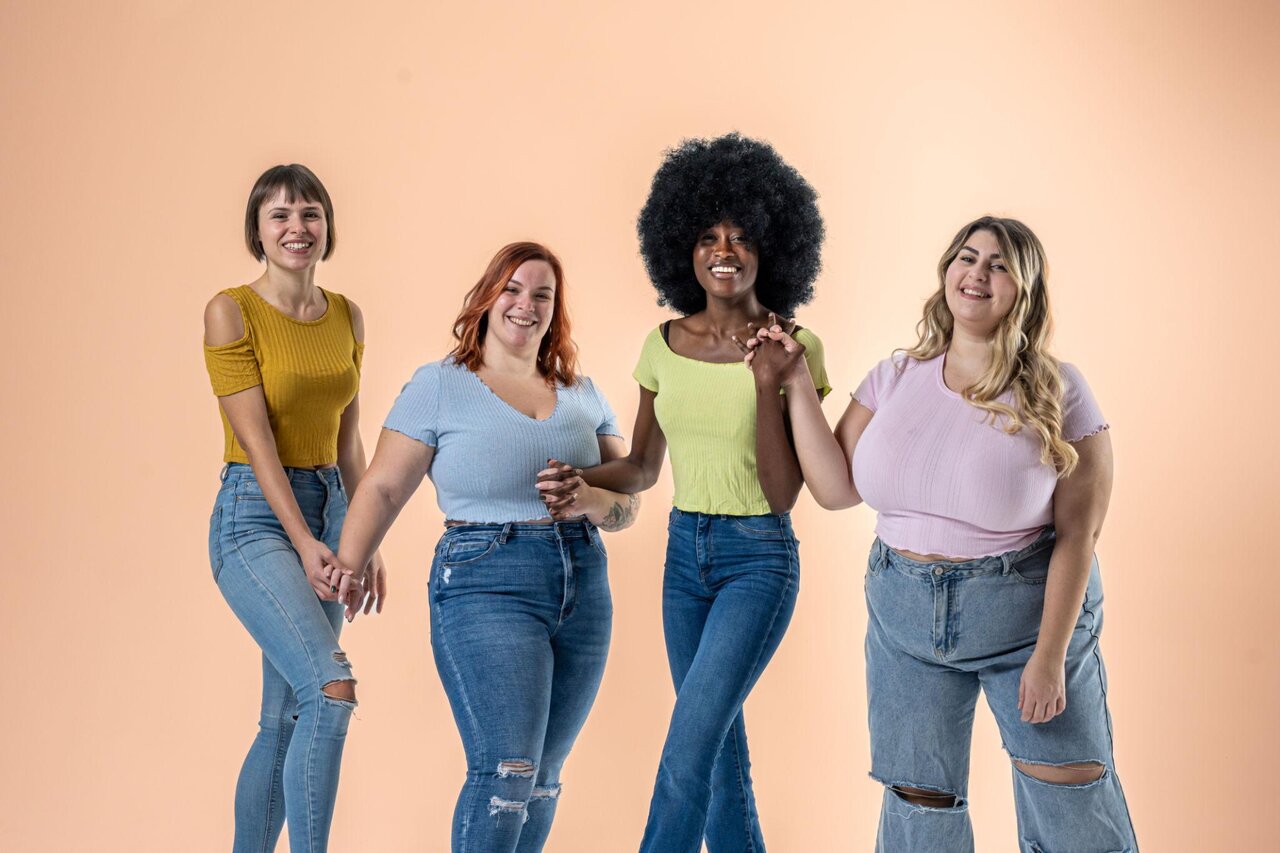 Grupo diverso de mulheres sorrindo em fundo suave.