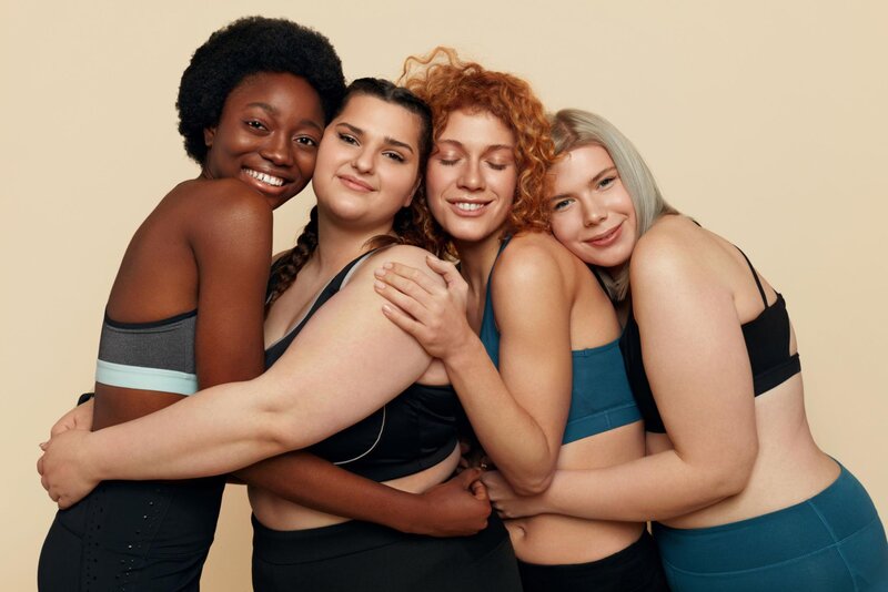 Grupo de mulheres diversas posando juntas e sorrindo